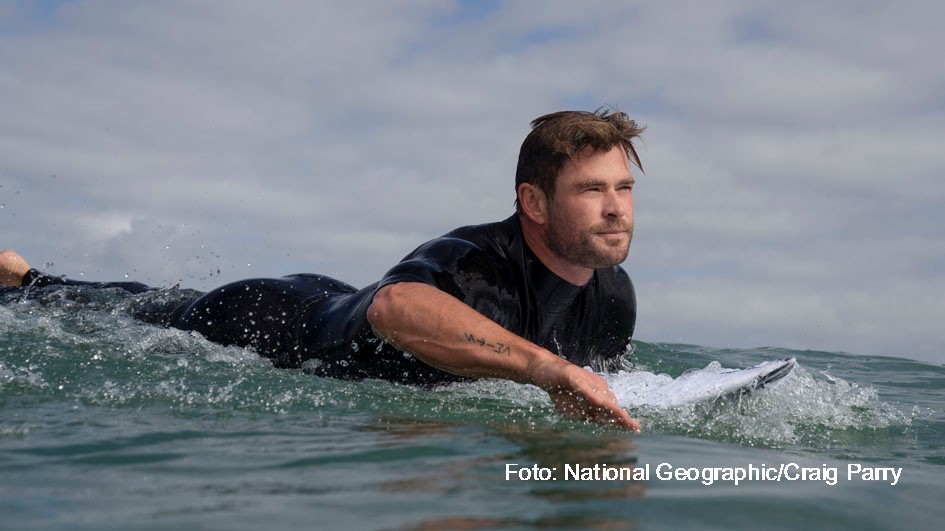 Chris Hemsworth paddling out to surf.  (National Geographic/Craig Parry)
