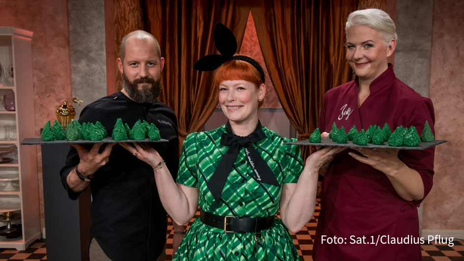 Moderatorin Enie van de Meiklokjes hat am heutigen 17. März im Halbfinale von „Das große Promibacken“ auch eine Aufgabe für die Juroren parat: Bettina Schliephake-Burchardt und Christian Hümbs sollen für die Spendenaktion zur „Wald-Rekordwoche“ essbare Bäume modellieren. (Foto: Sat.1/Claudius Pflug)