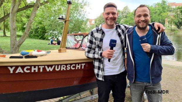 Gemeinsam haben Sternekoch Robin Pietsch und Mario D. Richardt ein altes Holzboot restauriert und sind damit auf Saale-Tour gegangen – unterstützt von der Countrysängerin Linda Feller. Was dabei passiert ist, zeigt die Doku „Abenteuer Saale“ in der ARD-Mediathek. (Foto: MDR)