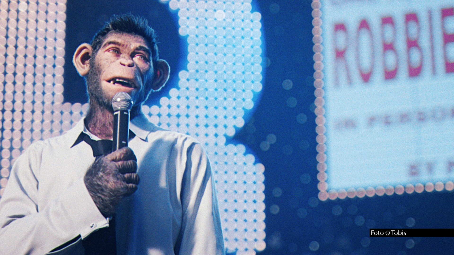 Am 2. August zeigt ProSieben ab 20:15 Uhr die deutsche Free-TV-Premiere von „Better Man – Die Robbie Williams Story". Der Film von „Greatest Showman"-Regisseur Michael Gracey erzählt das Leben des britischen Popstars, mit einem ungewöhnlichen Twist: Die Rolle des Robbie Williams übernimmt ein computergenerierter Schimpanse. Foto © TobisAm 2. August zeigt ProSieben ab 20:15 Uhr die deutsche Free-TV-Premiere von „Better Man – Die Robbie Williams Story". Der Film von „Greatest Showman"-Regisseur Michael Gracey erzählt das Leben des britischen Popstars, mit einem ungewöhnlichen Twist: Die Rolle des Robbie Williams übernimmt ein computergenerierter Schimpanse. Foto © Tobis