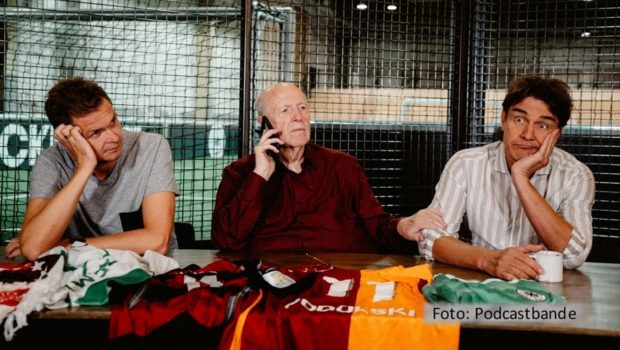 Auch für die Fußball-Podcaster Tobias Holtkamp, Reiner Calmund und Matze Knop hat die Saison 2024/25 begonnen. In der neuen Ausgabe blicken sie u.a. auf das anstehende Spitzenspiel in Leverkusen und erinnern darüber hinaus an den verstorbenen Trainer Christoph Daum. (Foto: Podcastbande)