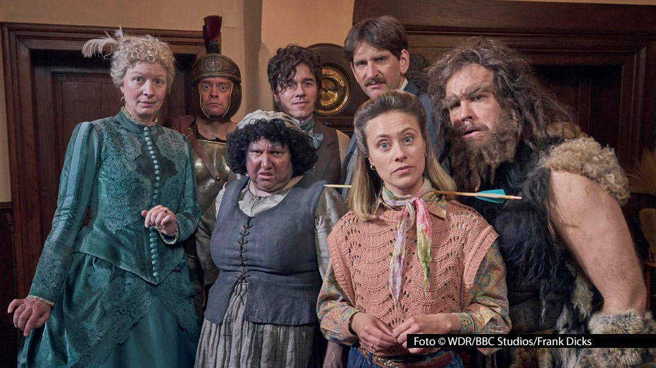 Unter Federführung des WDR ist die Comedy-Serie „Ghosts“ entstanden, die am 7. März in der ARD-Mediathek startet. Erzählt wird die Geschichte eines jungen Paares, das sich ein geerbtes Hausl mit einer Reihe von freundlichen Geistern – u.a. gespielt von Max Giermann, Meltem Kaptan, Sina Tkotsch und Jan van Weyde – teilen muss. (Foto: WDR/BBC Studios/Frank Dicks)