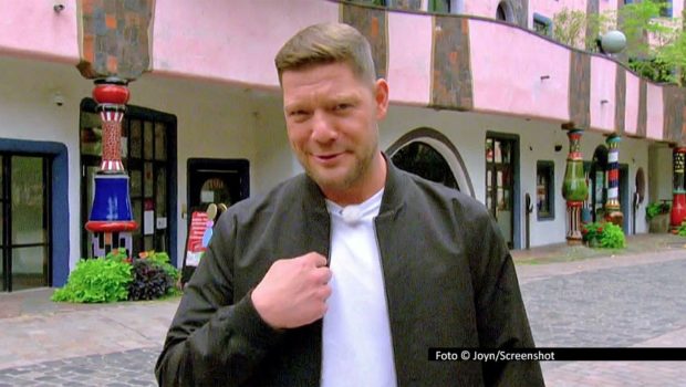 Am Hundertwasserhaus in Magdeburg beginnt am 1. Dezember der neue Einsatz von Robin Pietsch als Moderator der Kabel Eins-Reihe „Mein Lokal, Dein Lokal“. Der Zwei-Sterne-Koch aus dem Harz begleitet den kulinarischen Wettbewerb diesmal im heimischen Sachsen-Anhalt. Foto © Joyn/Screenshot