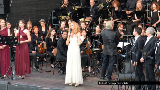 Gleich an zwei Abenden spielt das „Orchestra on the Rocks“ bei den Eutiner Festspielen 2025. Rock-, Pop- und Musical-Songs im symphonischen Gewand. Mit dabei ist Sonya Kraus, die als Moderatorin durch den vielfältigen und vom Publikum umjubelten musikalischen Abend führt.Foto_Eutiner-Festspiele