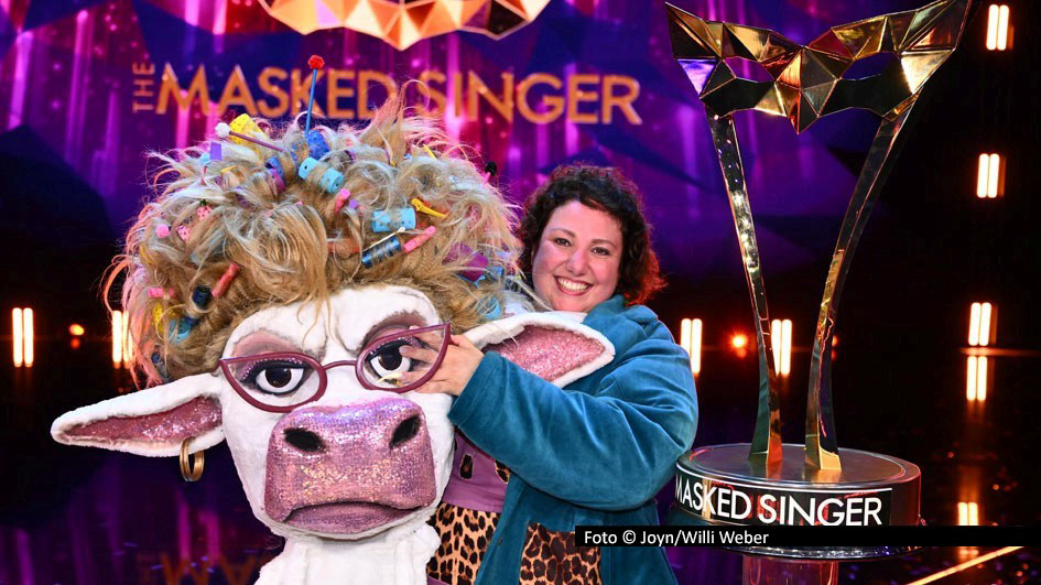 Staffel 12 der ProSieben-Show „The Masked Singer“ endete am 13. Dezember mit dem Sieg von „Muuhnika“. Hinter der Maske der stimmgewaltigen Kuh mit der spektakulären Lockenwickler-Frisur verbarg sich Schauspielerin, Moderatorin und Komikerin Meltem Kaptan. Nach dem Finale, in dem sie sich in der Gunst des Publikums u.a. gegen „Rave-ioli“ Pietro Lombardi durchsetzte, sprach die Kölnerin mit smalltalk über ihre Maske, die Geheimhaltung rund um die Show und über ihre musikalischen Vorlieben. Foto © Joyn/Willi Weber