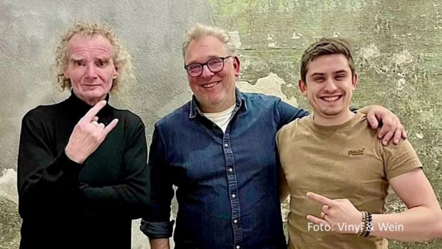 Podcaster und Feinkost-Experte Boris Rogosch trifft für sein Audio-Format „Vinyl & Wein“ regelmäßig musikaffine Gäste wie Wacken-Veranstalter Holger Hübner, um mit ihnen über ihre Lieblingssongs und vieles mehr zu sprechen. Sommelier Jonas Hauke begleitet den Talk mit einer Weinauswahl. (Foto: Vinyl & Wein)